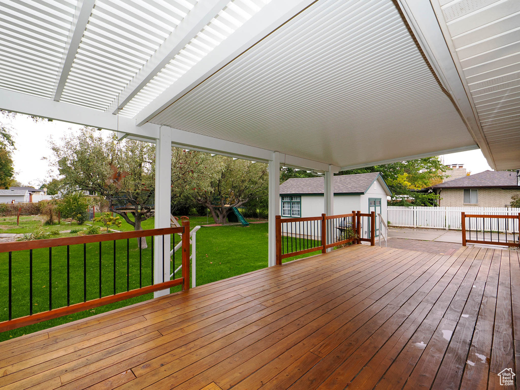 Wooden deck with a playground and a lawn