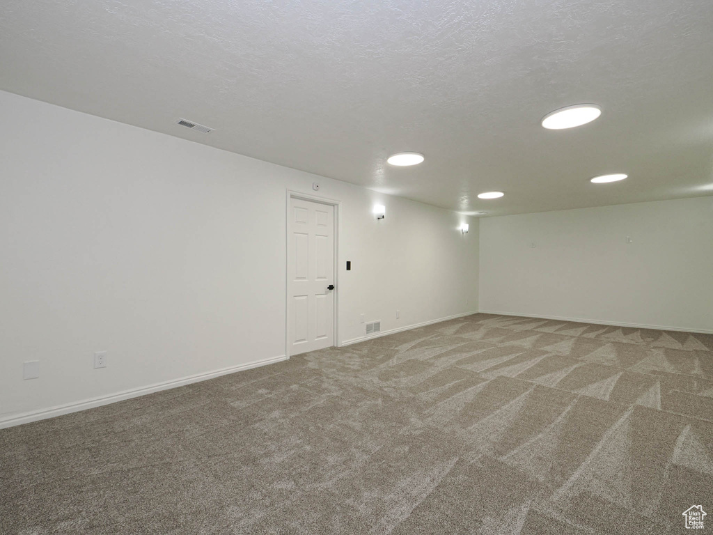 Unfurnished room with a textured ceiling and carpet