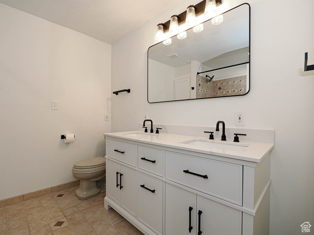 Bathroom with toilet, vanity, and walk in shower