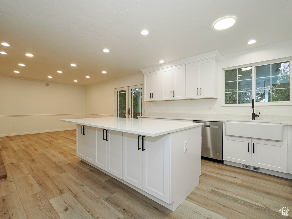 Kitchen featuring stainless steel dishwasher, a healthy amount of sunlight, and a center island