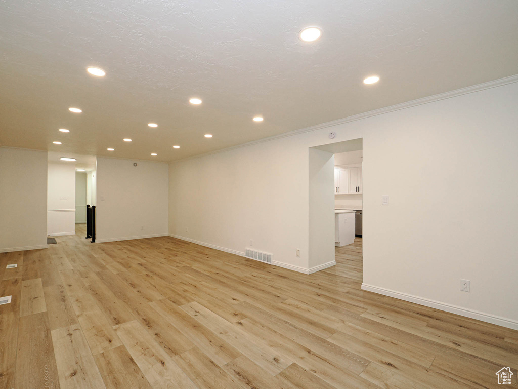 Unfurnished room featuring ornamental molding and light hardwood / wood-style flooring