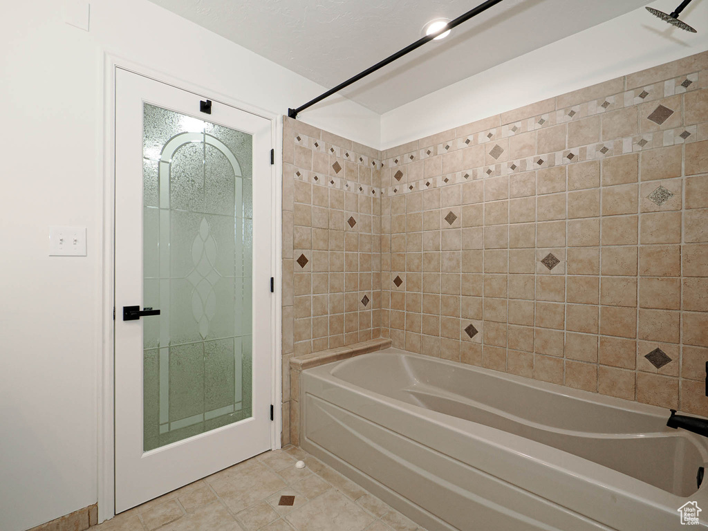 Bathroom with tiled shower / bath and tile patterned floors