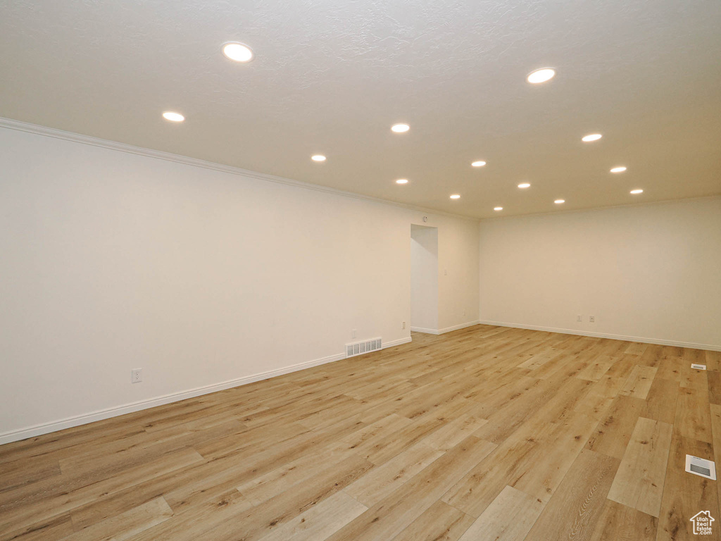 Unfurnished room featuring light wood-type flooring and crown molding