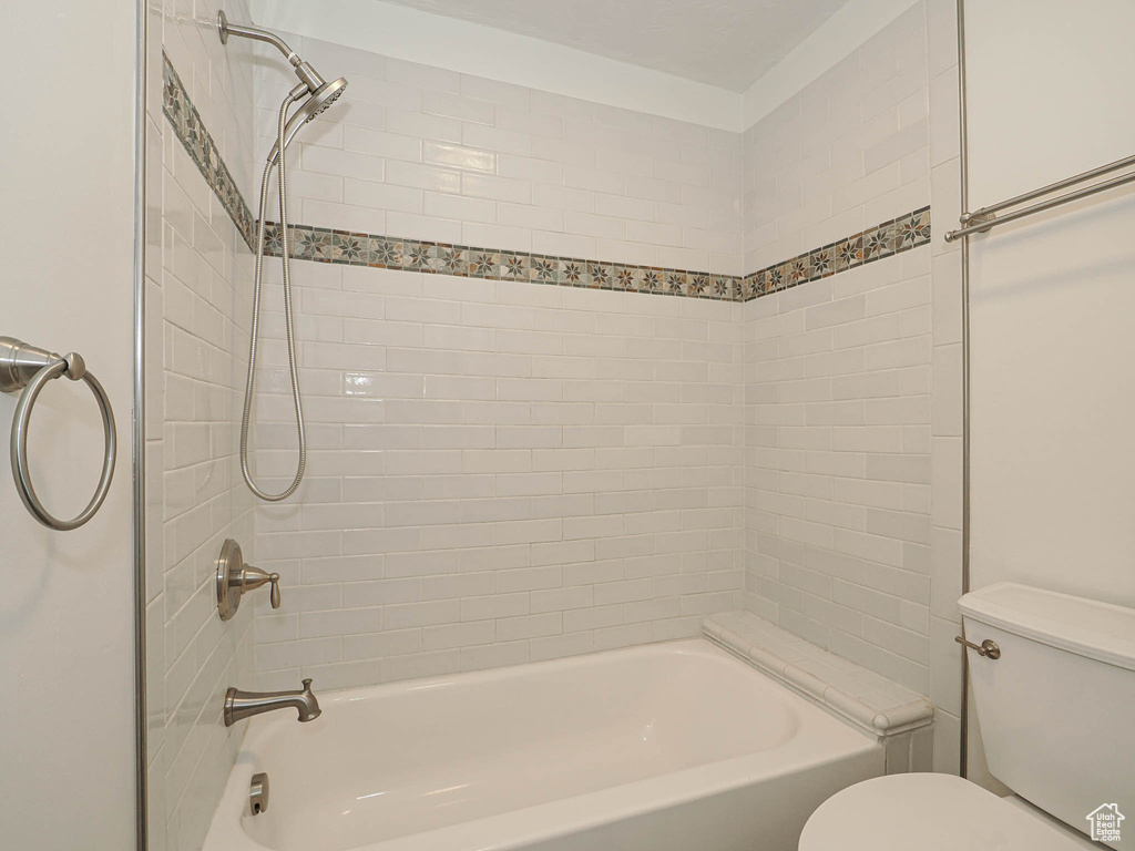 Bathroom featuring tiled shower / bath and toilet