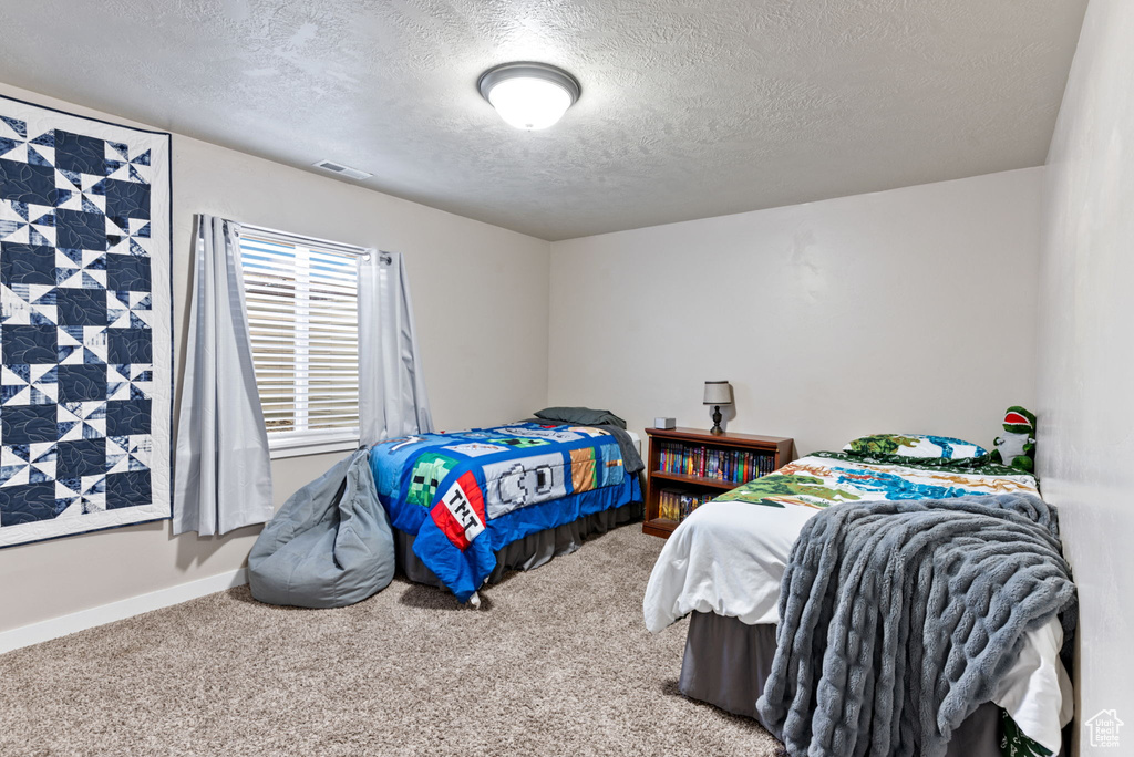 Carpeted bedroom featuring a textured ceiling