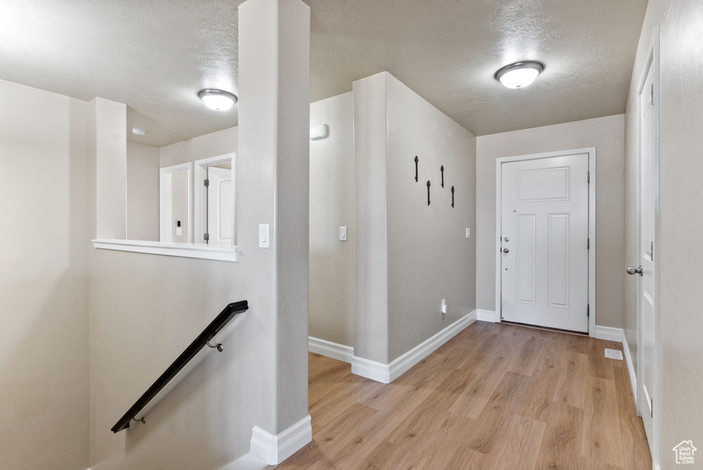 Entrance foyer featuring a textured ceiling and light hardwood / wood-style flooring