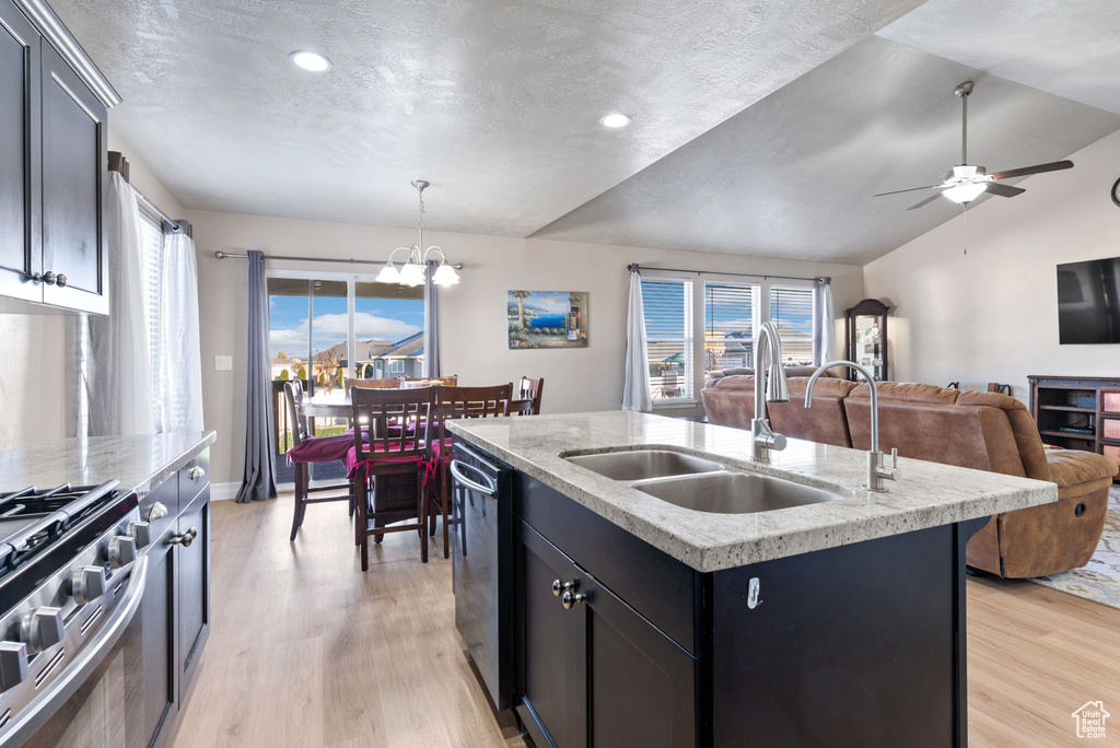 Kitchen featuring an island with sink, sink, light wood-type flooring, and appliances with stainless steel finishes