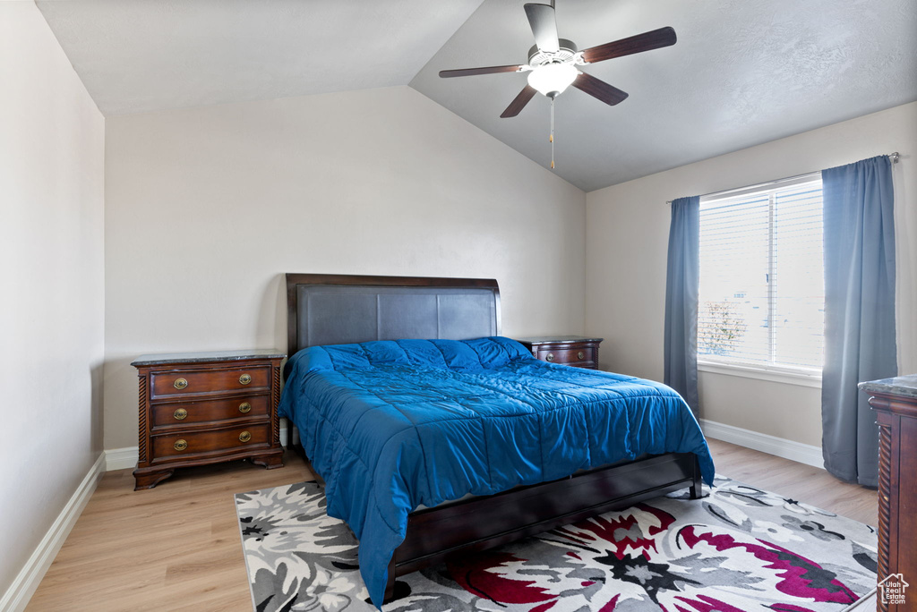 Bedroom with light wood-type flooring, lofted ceiling, and ceiling fan