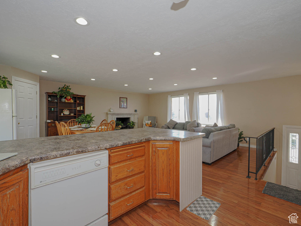 Kitchen with white appliances and light hardwood / wood-style flooring