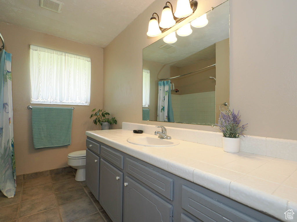 Bathroom with tile patterned flooring, vanity, toilet, and a shower with curtain