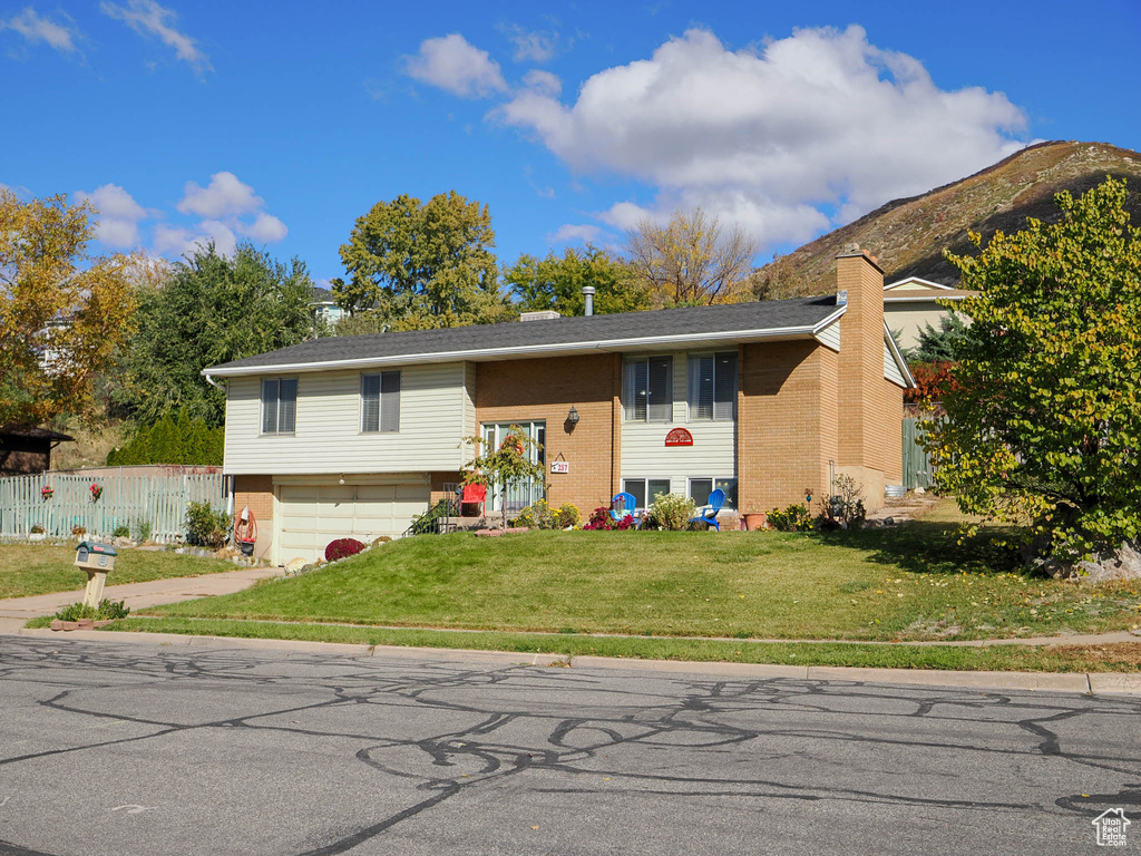 Bi-level home with a front lawn and a garage