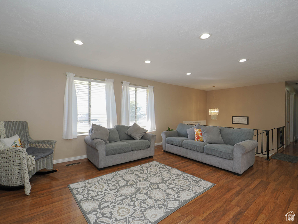 Living room with a notable chandelier and dark hardwood / wood-style floors