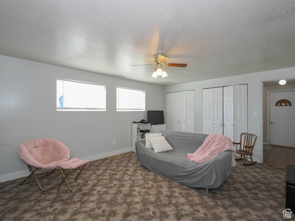 Living room featuring a textured ceiling and ceiling fan