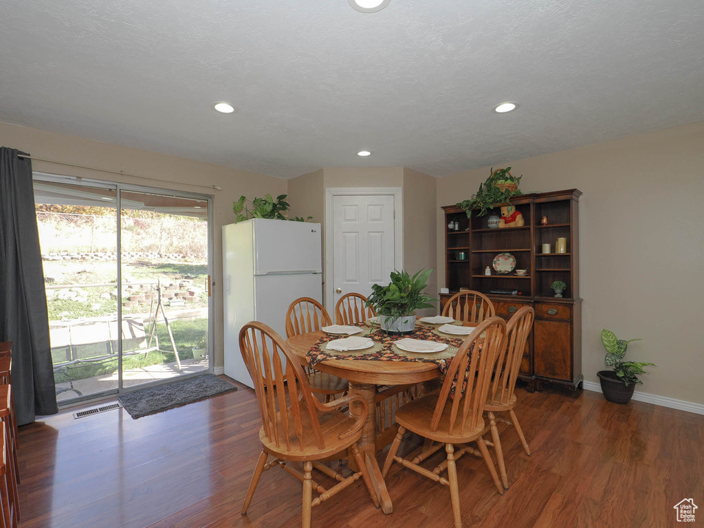 Dining space with dark hardwood / wood-style floors and a textured ceiling