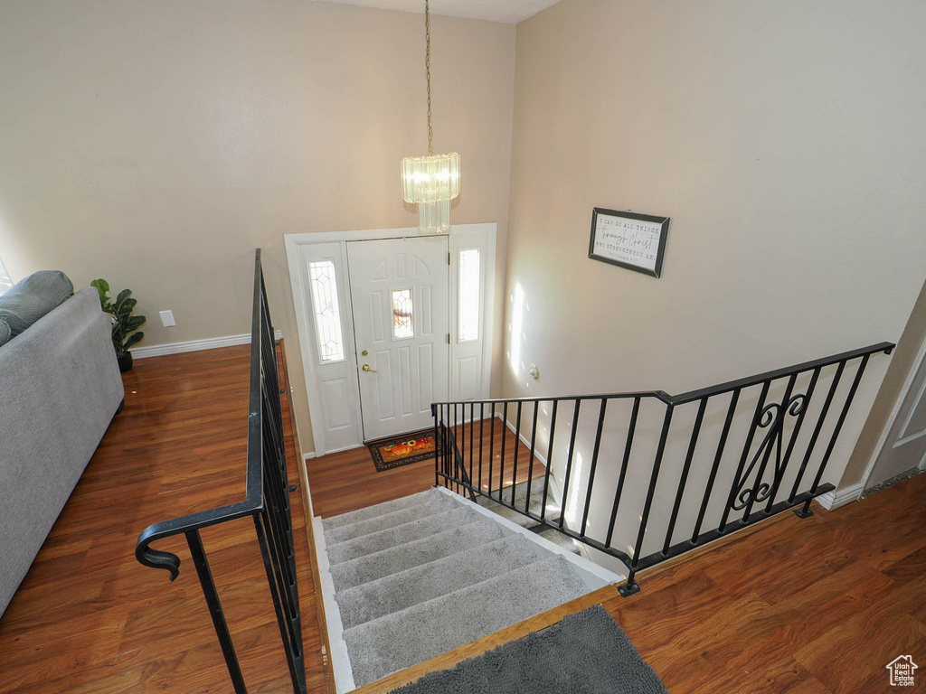 Entryway with a high ceiling, dark hardwood / wood-style flooring, and a notable chandelier