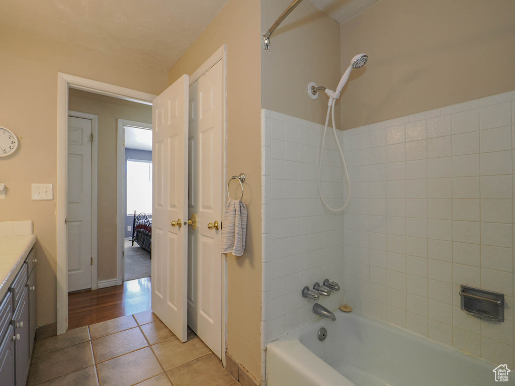 Bathroom featuring tile patterned flooring, vanity, and tiled shower / bath combo