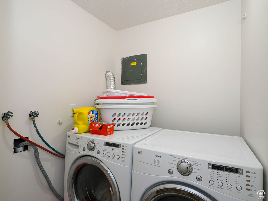 Laundry room with electric panel and separate washer and dryer