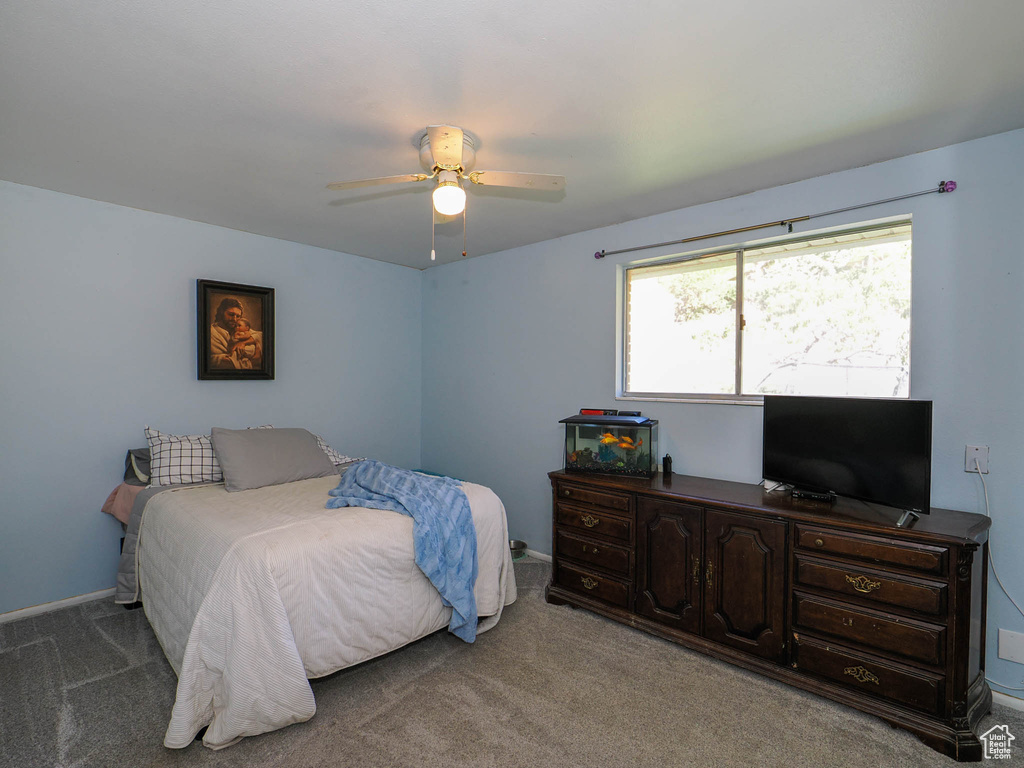 Carpeted bedroom featuring ceiling fan