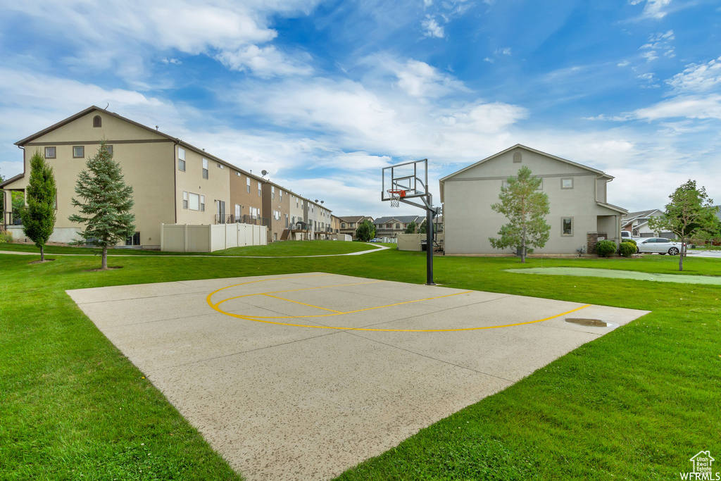 View of sport court with a lawn