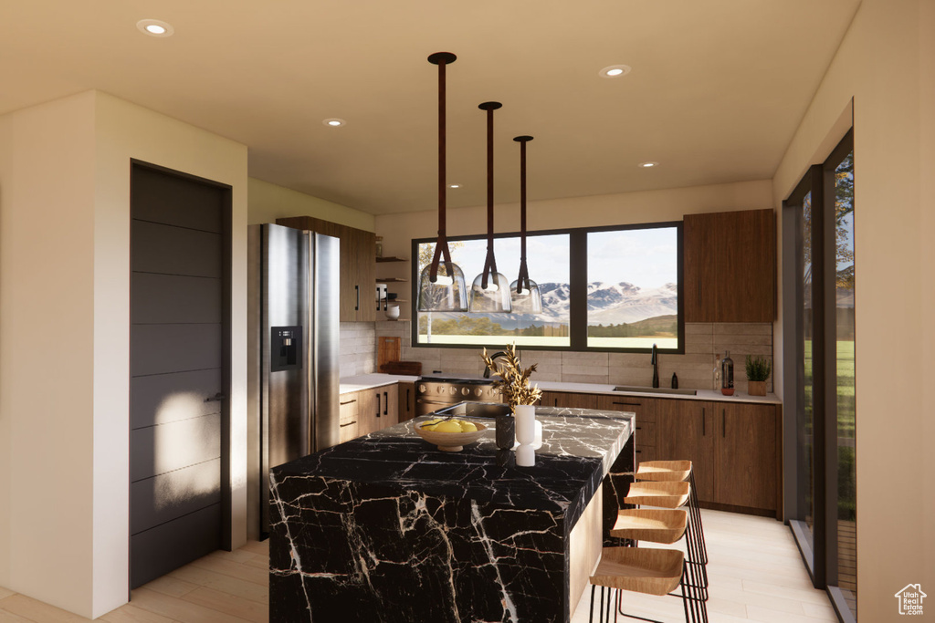 Kitchen with a center island, sink, tasteful backsplash, a mountain view, and dark stone countertops