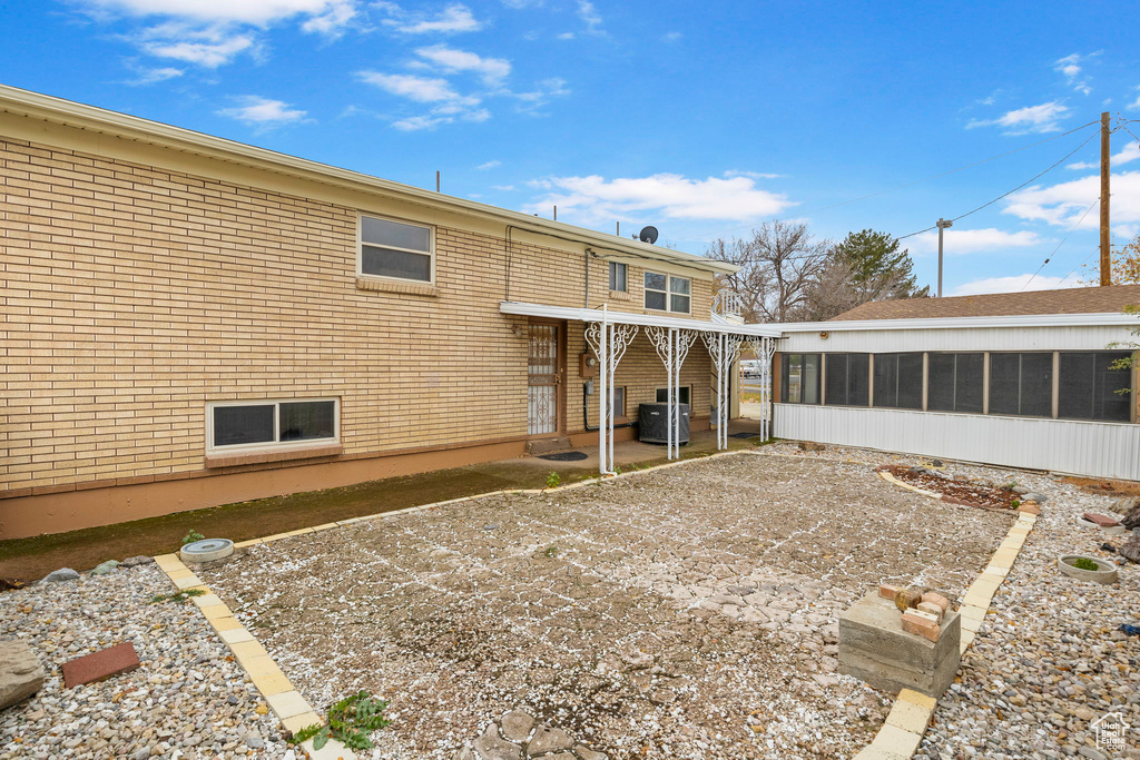 Rear view of house with a patio area and a sunroom