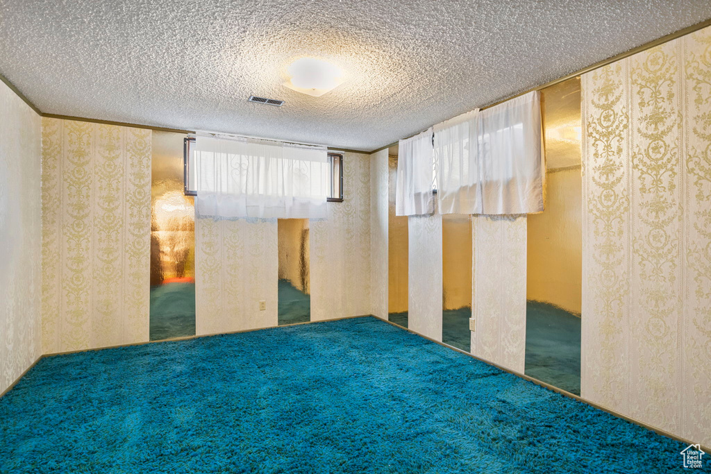 Spare room featuring a textured ceiling and carpet floors