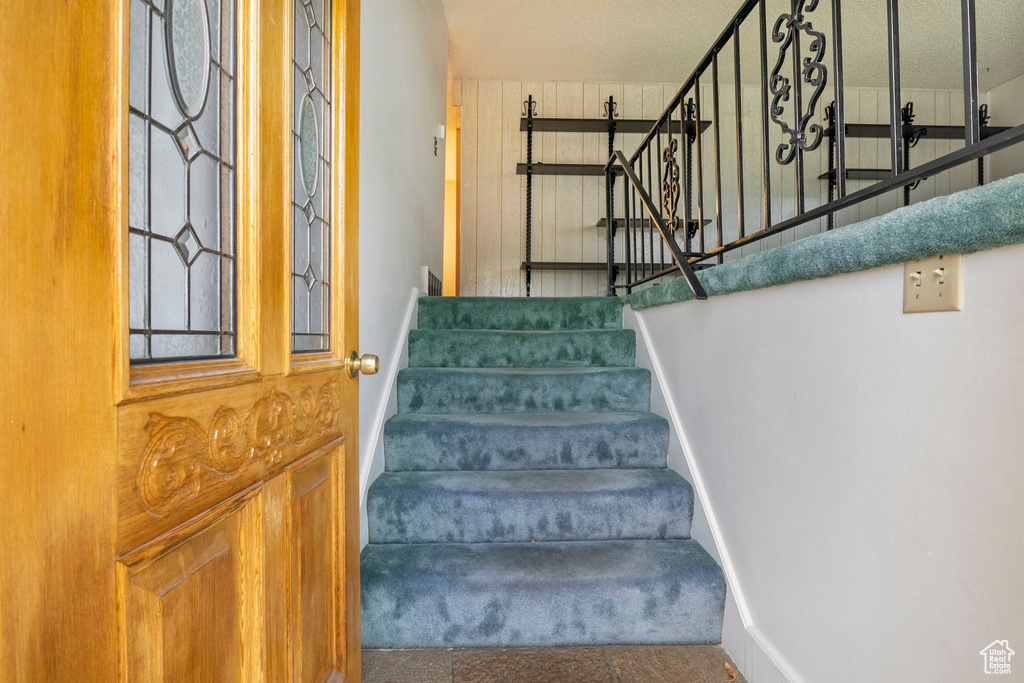 Staircase featuring a textured ceiling