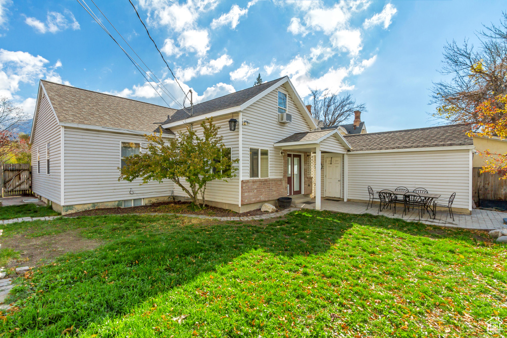 Rear view of property featuring a patio and a yard