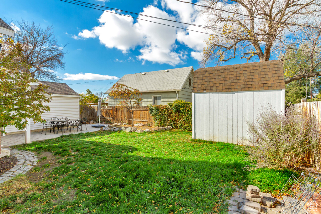 View of yard with a shed and a patio area