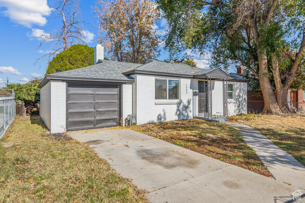 Bungalow-style home with a garage and a front lawn