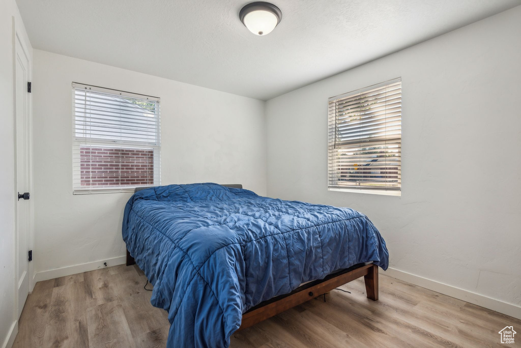 Bedroom with multiple windows and hardwood / wood-style flooring