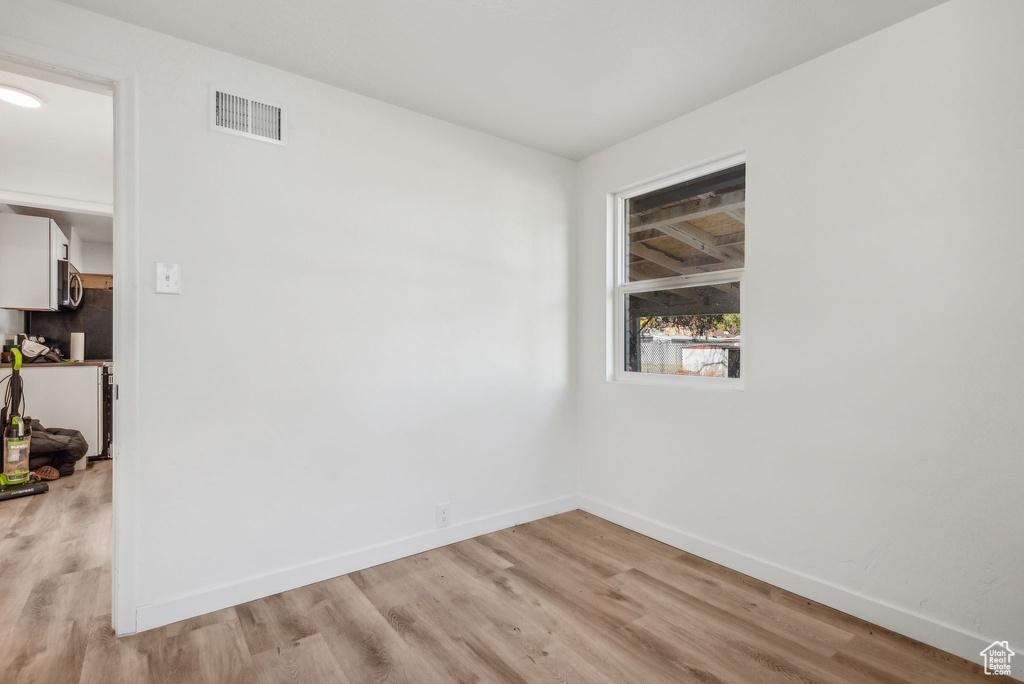 Empty room with light hardwood / wood-style floors