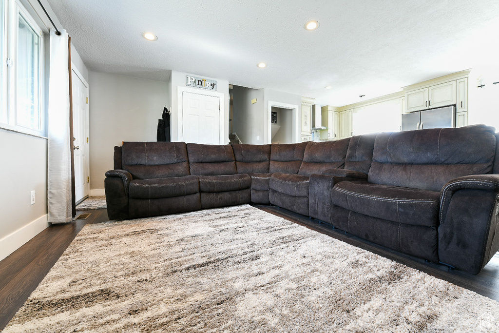 Living room featuring dark hardwood / wood-style flooring and a textured ceiling