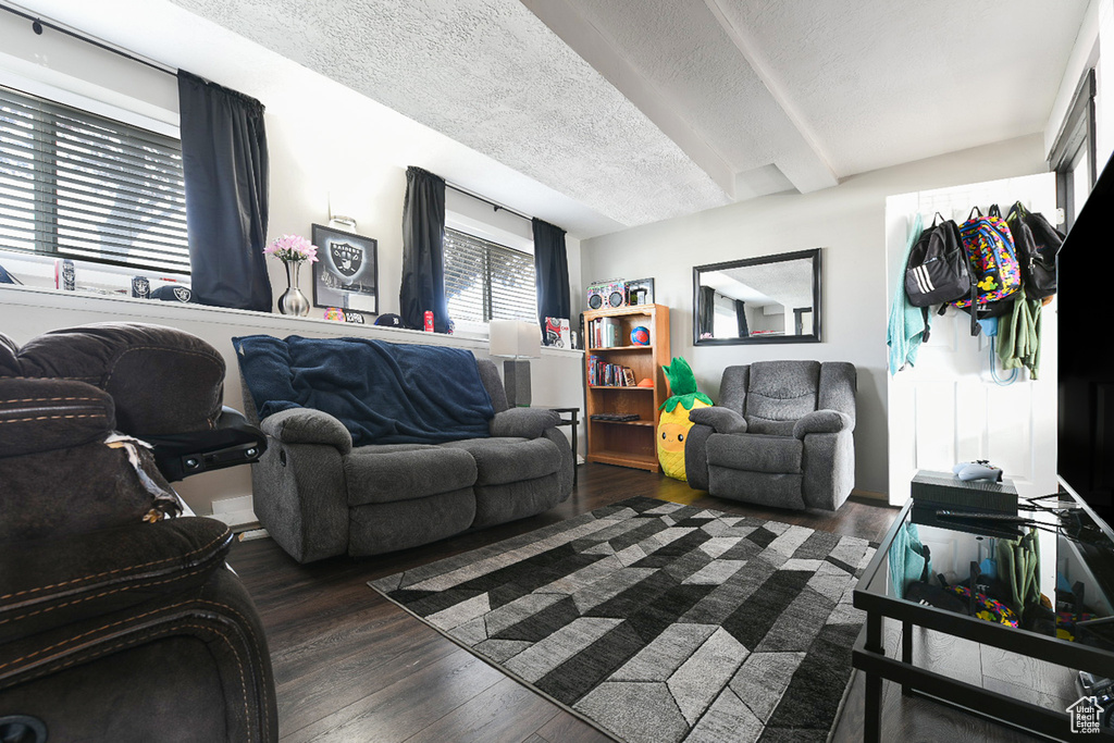 Living room featuring a textured ceiling and dark hardwood / wood-style flooring