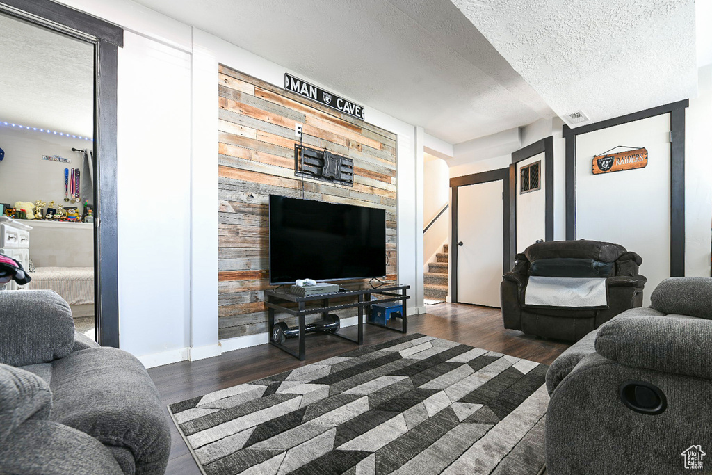 Living room with dark wood-type flooring and a textured ceiling