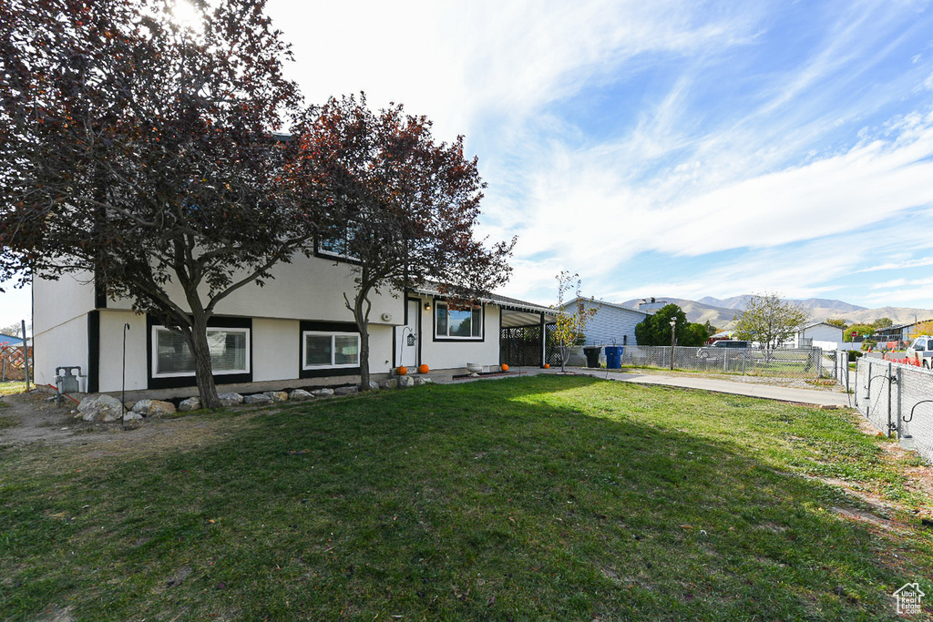 View of front facade with a mountain view and a front yard