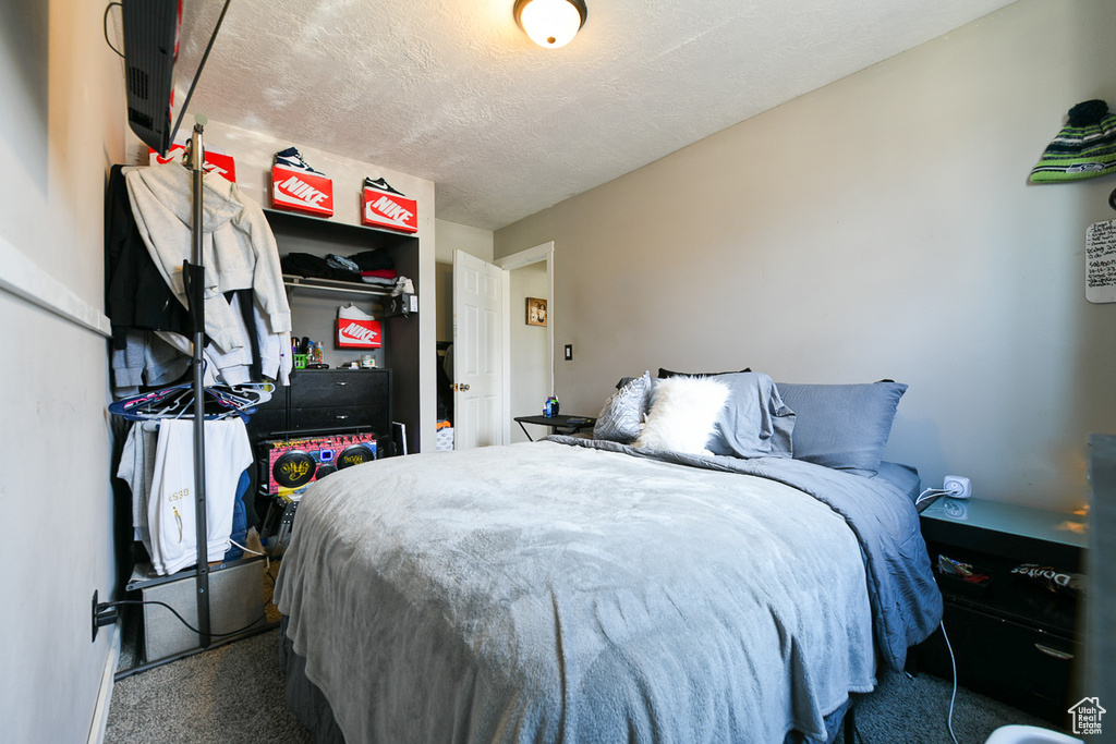 Bedroom featuring a textured ceiling and carpet floors