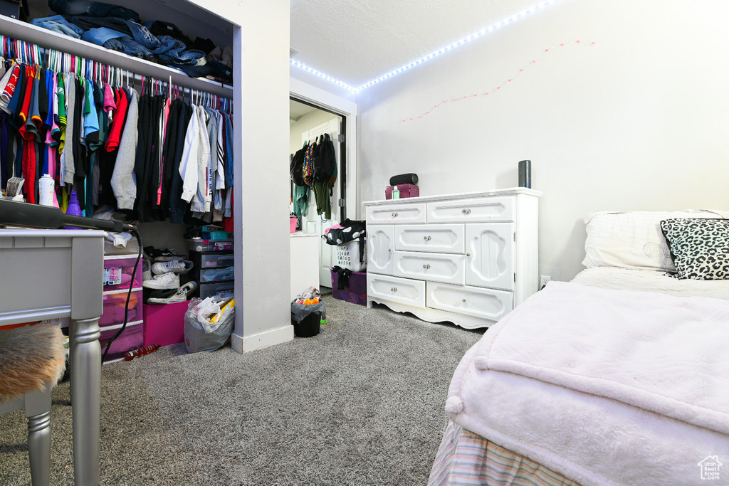 Bedroom with carpet floors, a textured ceiling, and a closet