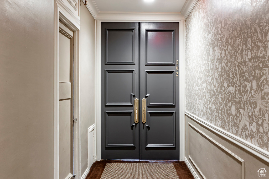 Entryway with dark hardwood / wood-style floors and ornamental molding