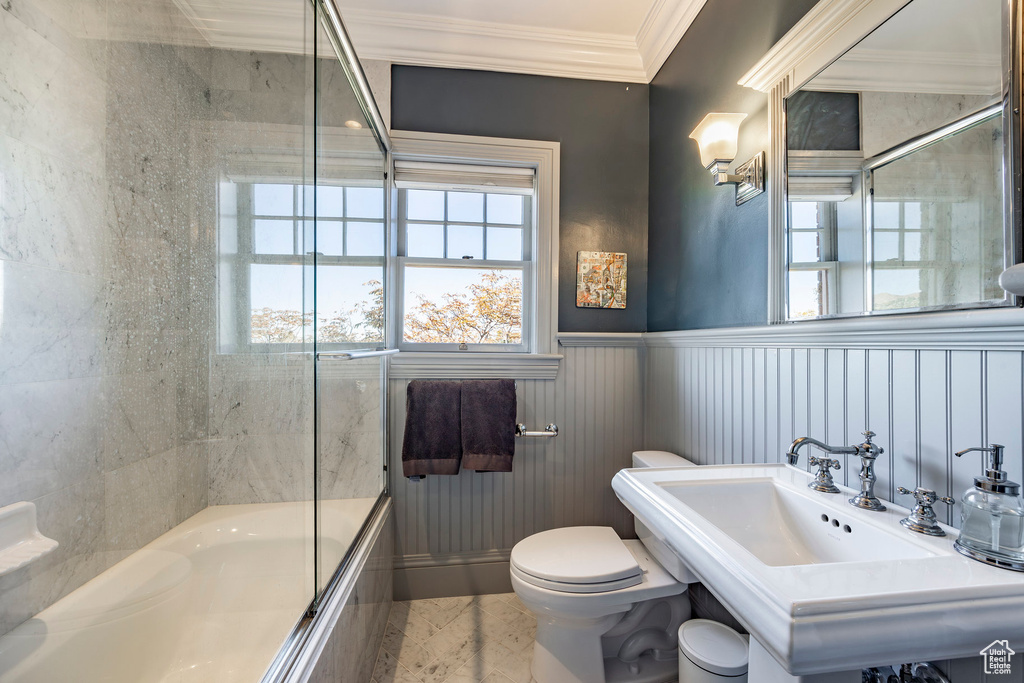 Bathroom featuring enclosed tub / shower combo, toilet, and ornamental molding