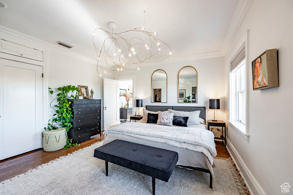 Bedroom with a chandelier, crown molding, and dark hardwood / wood-style flooring