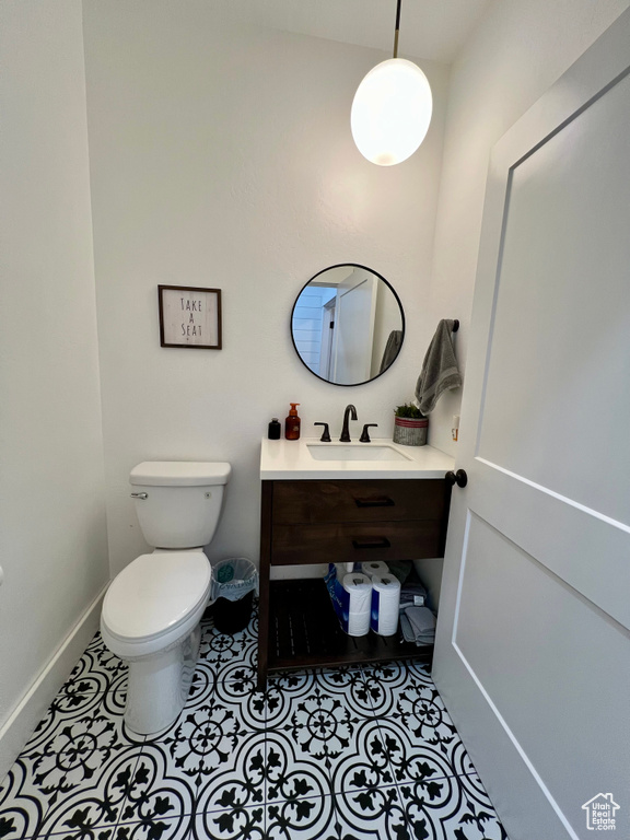 Bathroom featuring toilet, vanity, and tile patterned flooring