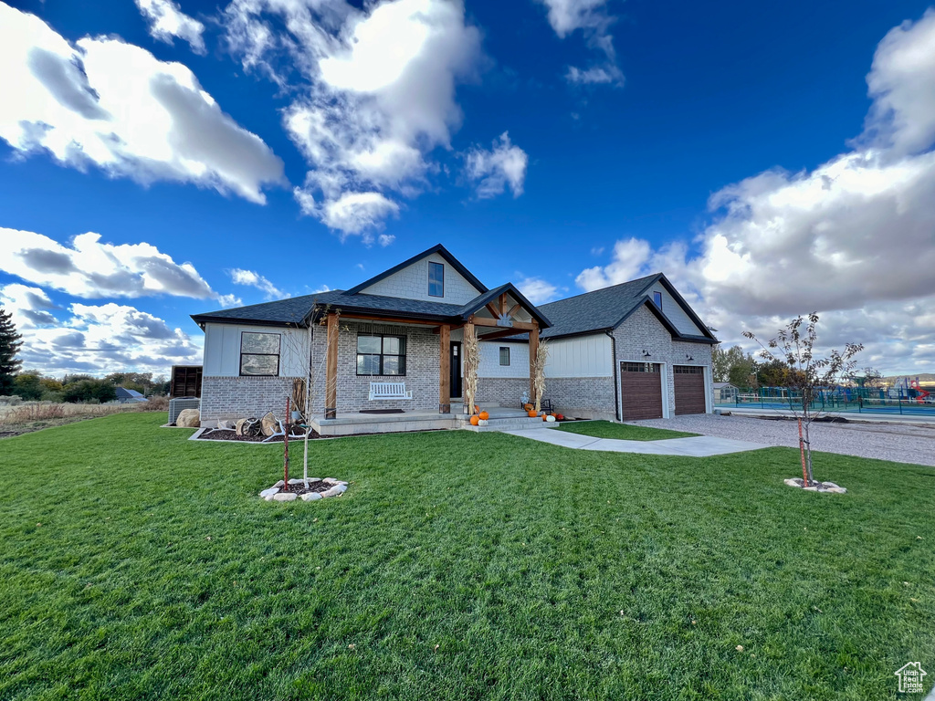 Craftsman-style home featuring a garage and a front lawn