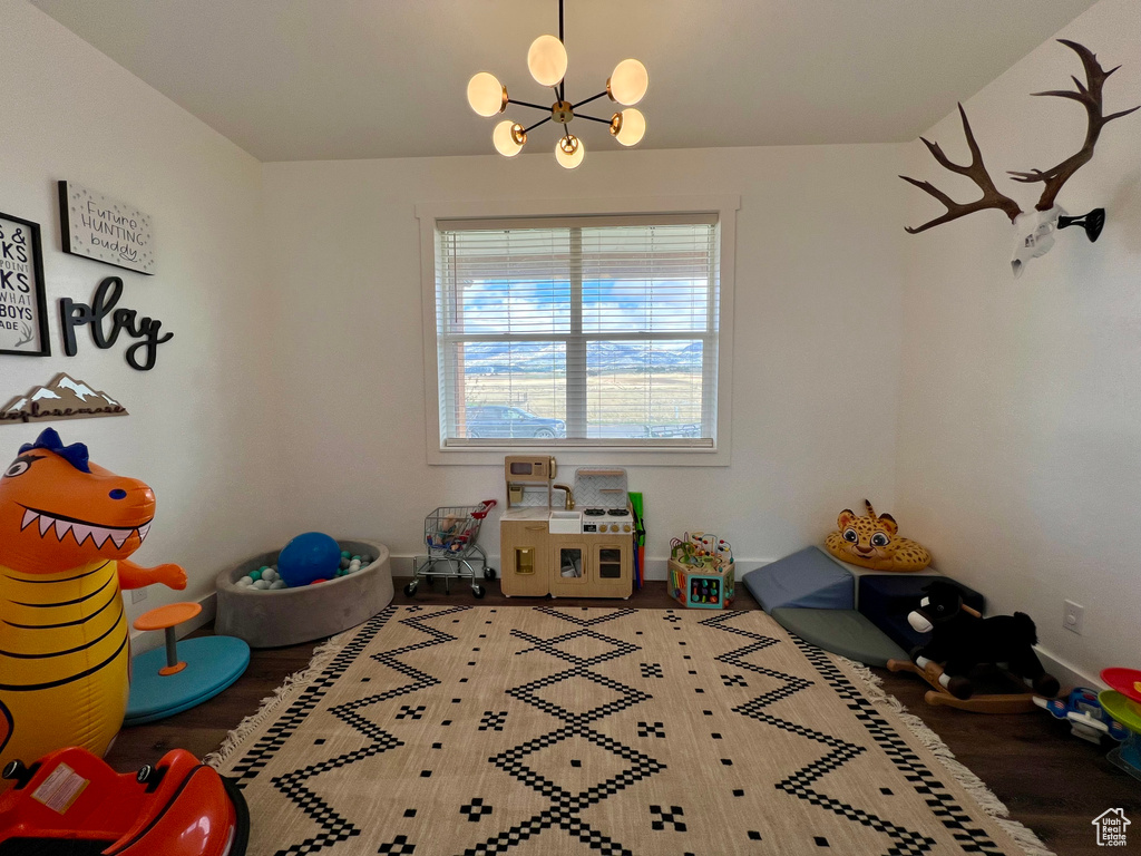 Game room featuring wood-type flooring and an inviting chandelier