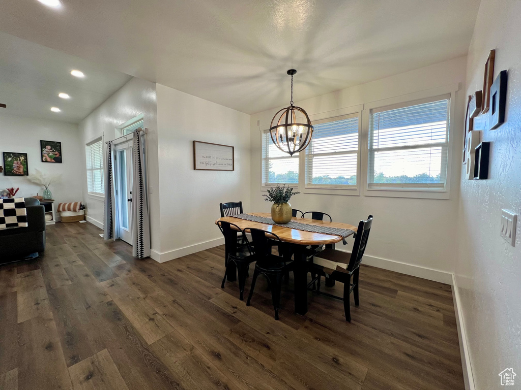 Dining area featuring a notable chandelier and dark wood-type flooring