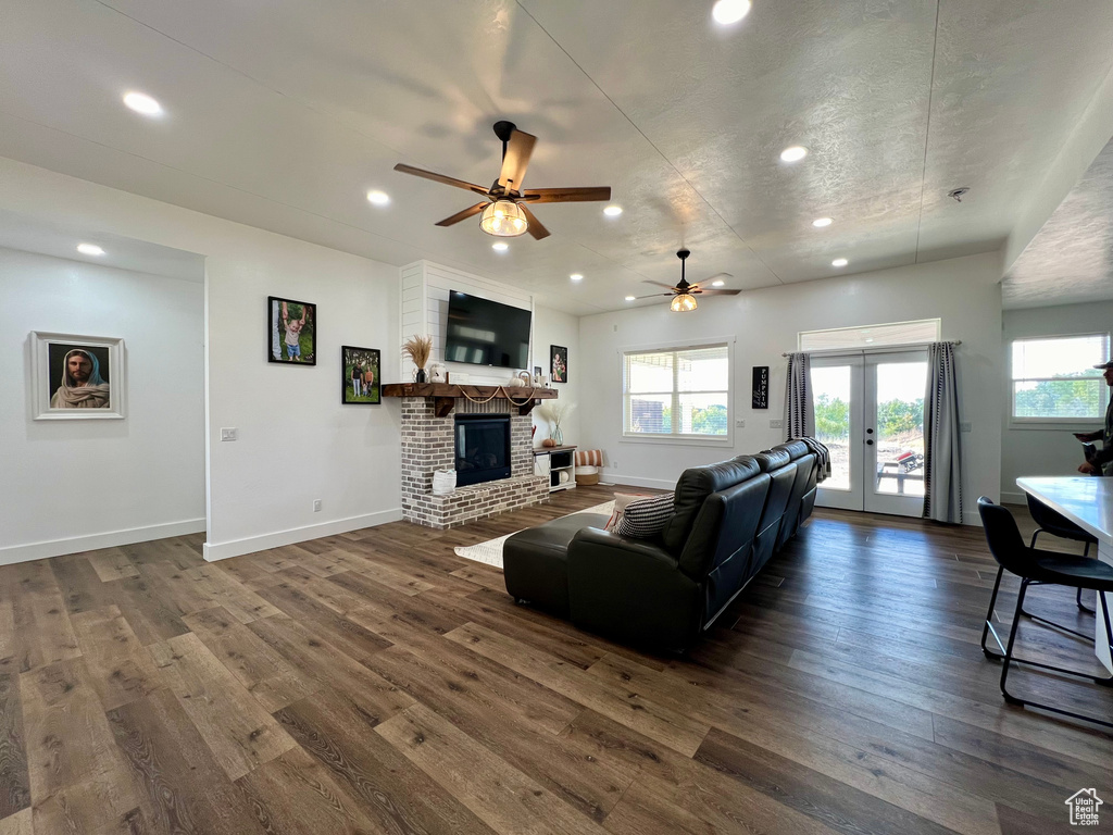 Living room with ceiling fan, a healthy amount of sunlight, and dark hardwood / wood-style floors