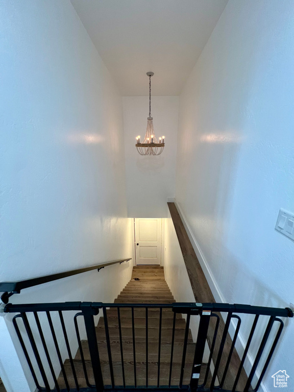 Staircase featuring a notable chandelier