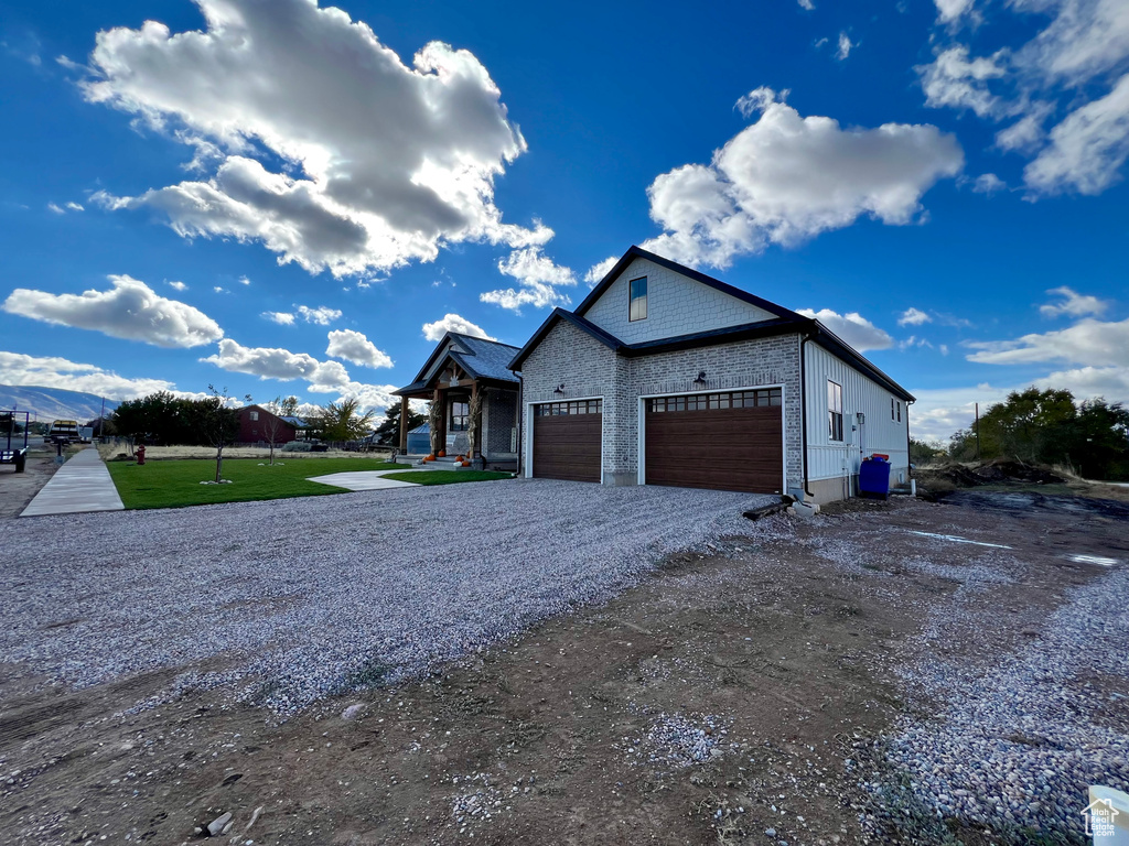 View of front facade featuring a front yard and a garage