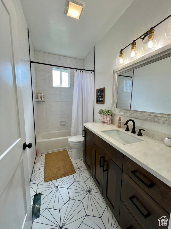 Full bathroom featuring vanity, toilet, tile patterned flooring, and shower / tub combo with curtain