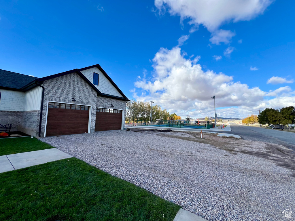 View of side of property featuring a yard and a garage